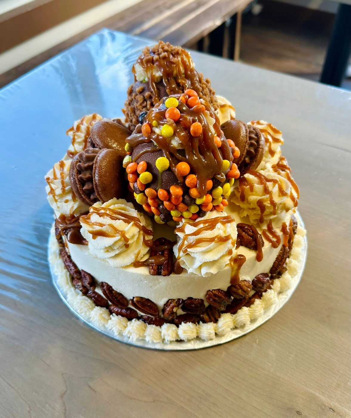 Towering caramel and peanut butter cake loaded with chocolate and pecans