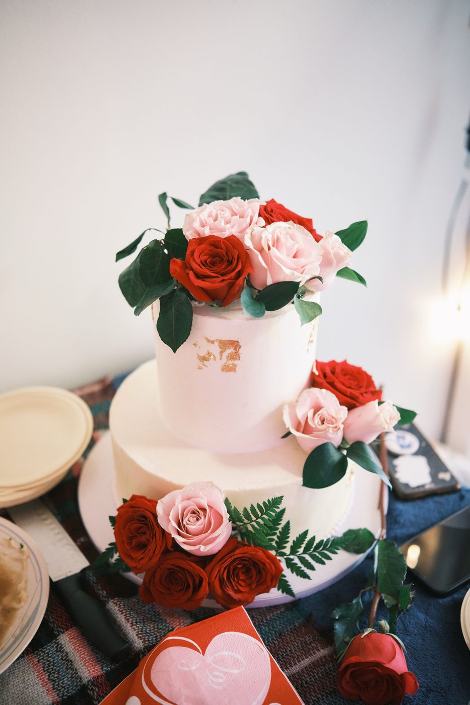 Two-tier wedding cake decorated with red and pink roses