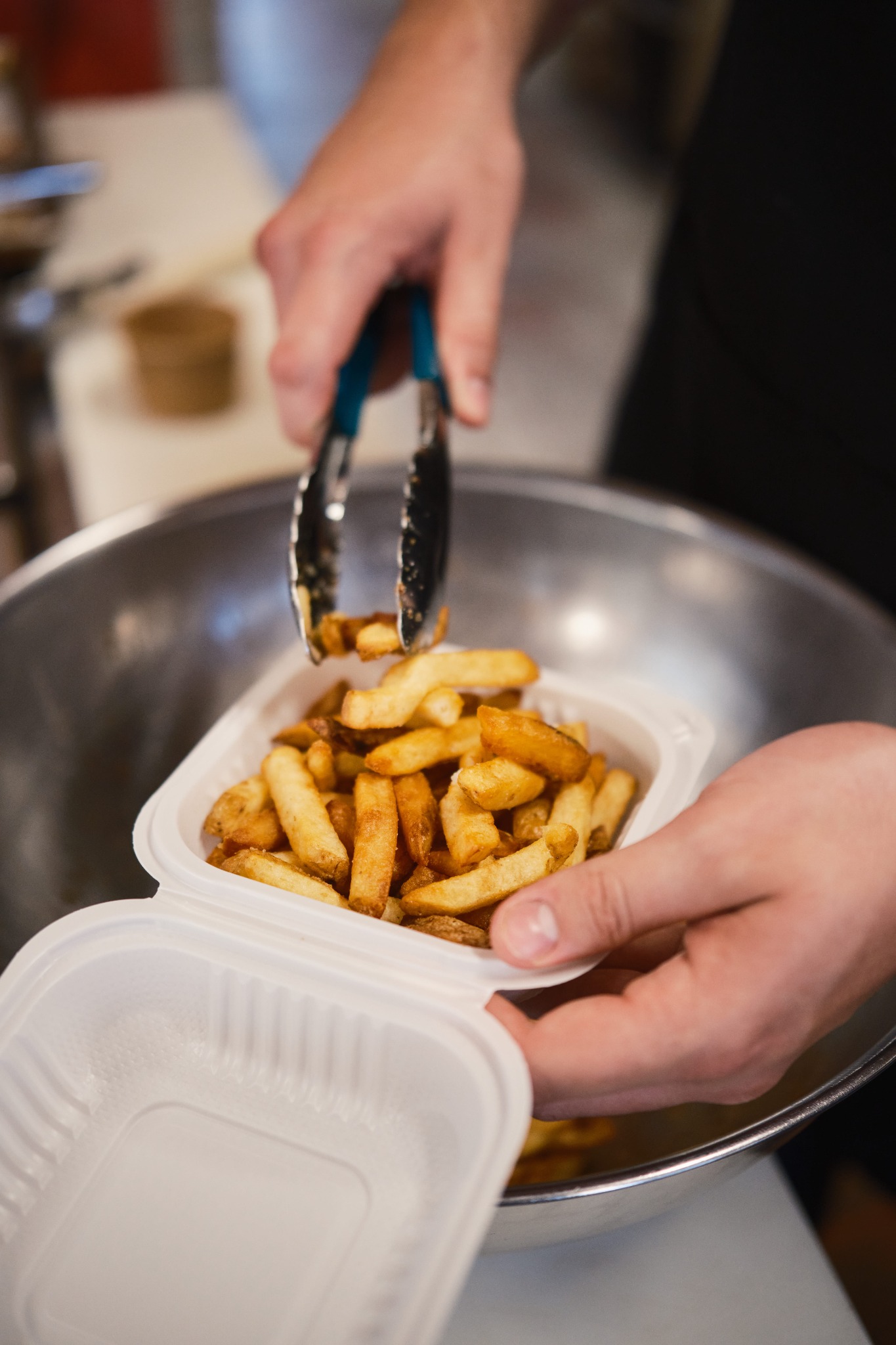 Golden hand‑cut fries in a takeout box