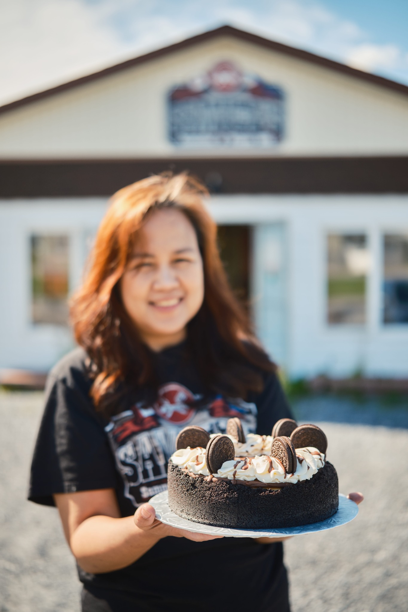 Cristina holding one of her hand-decorated cakes