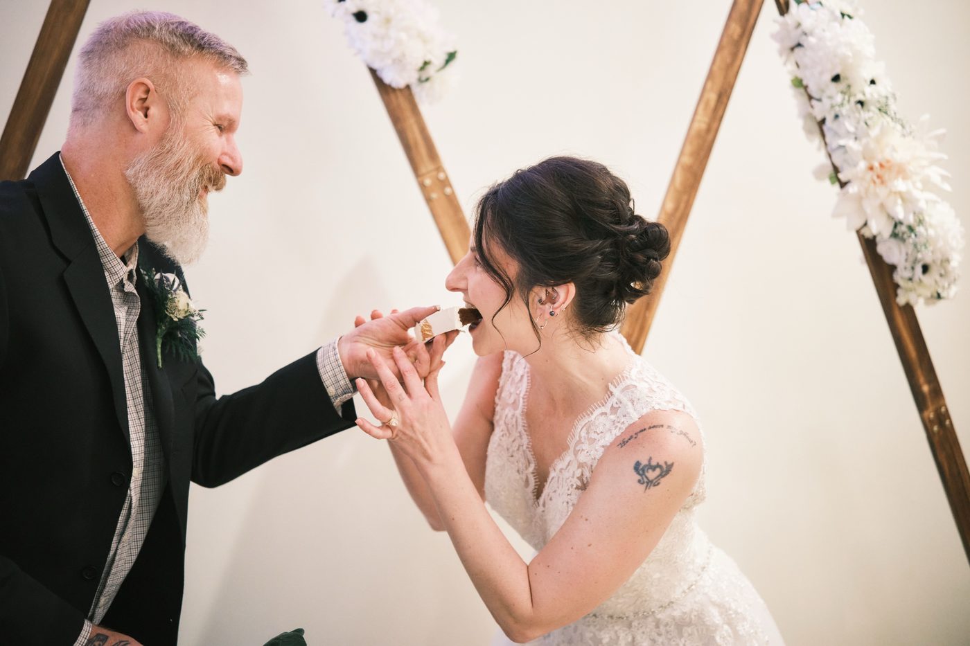 Newlyweds feeding each other a bite of cake